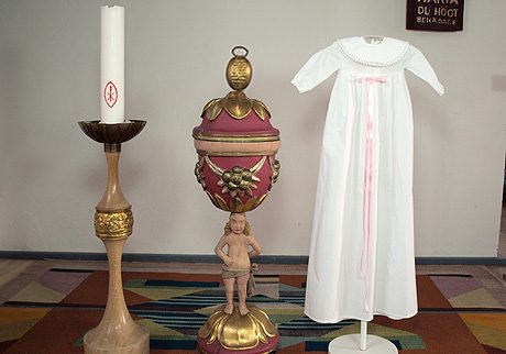 Minimundus dopklänning av ekologisk bomull med rosa satinband och rund krage med spets